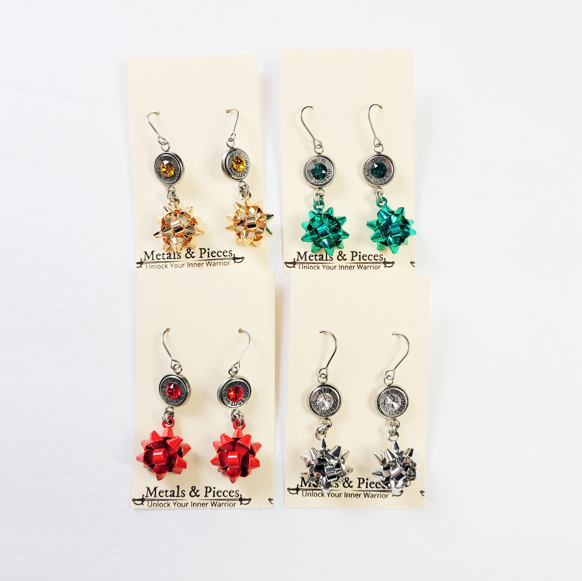 Gun-themed Christmas earrings in red, green, gold, and silver
